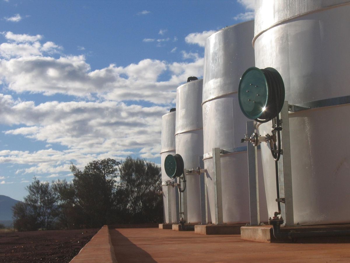 A row of vertical treatment vessels with sight-glass inspection covers, mounted on a concrete plinth.